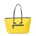 Bolso de hombro con ojos de monstruo, cremallera enrollable, piel texturizada amarilla