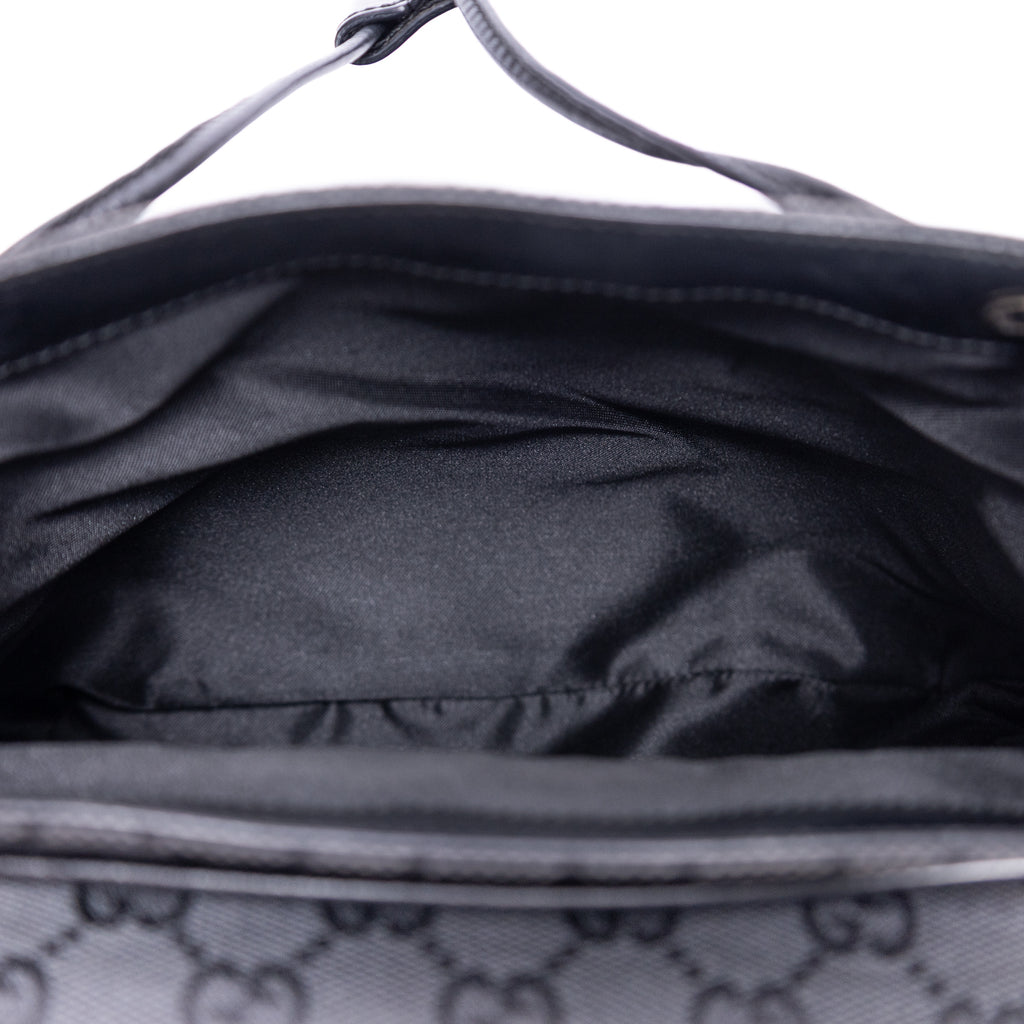 Mochila de lona con monograma negro pequeño con solapa y bolsillo frontal con cremallera