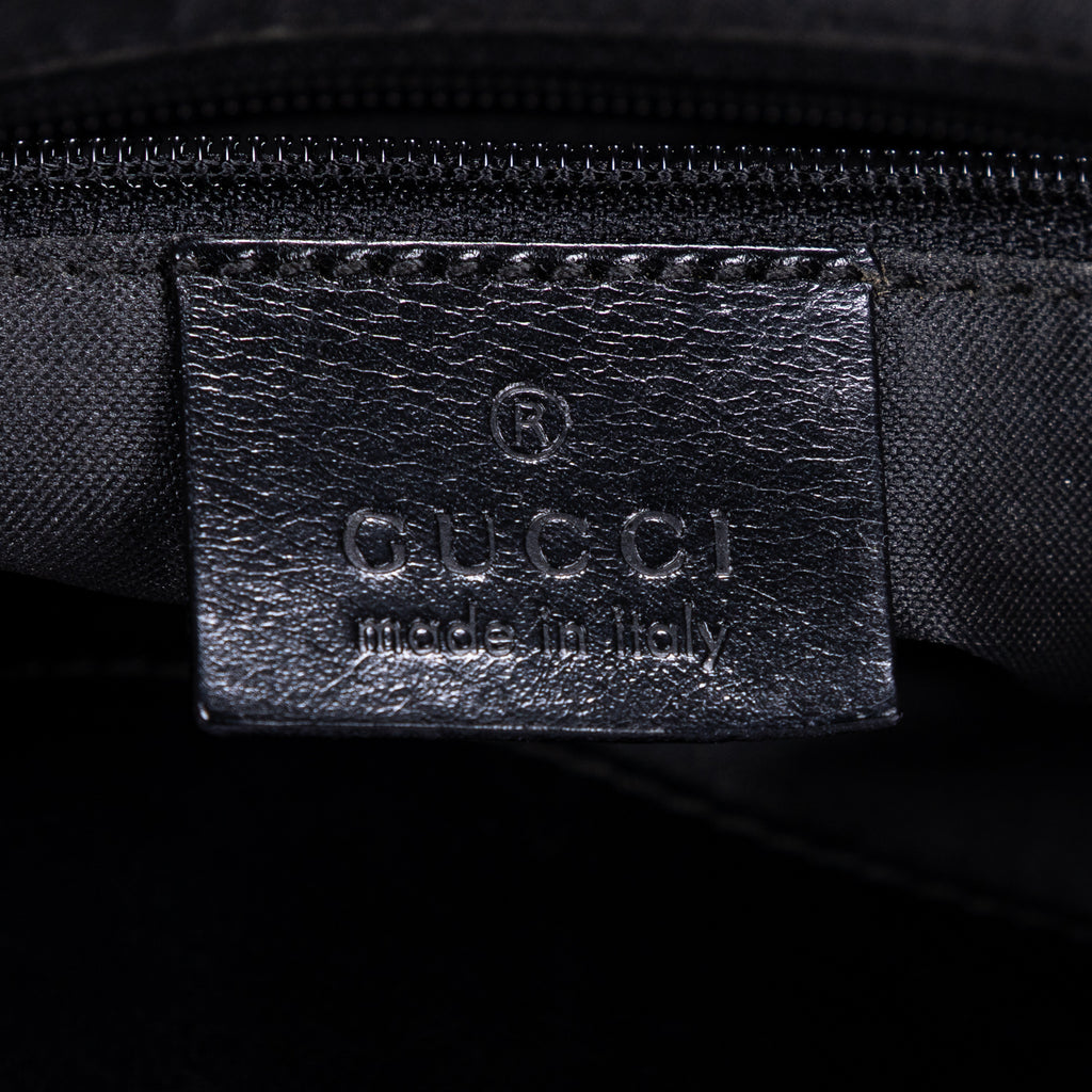 Mochila de lona con monograma negro pequeño con solapa y bolsillo frontal con cremallera